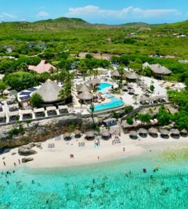 "Playa Kalki in Curaçao, a peaceful beach known for clear waters and coral reefs, with Playa Beach Club offering a relaxing atmosphere and delicious dining.