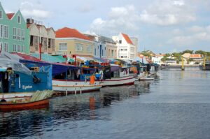 Travelers exploring Curaçao on a budget, visiting colorful Willemstad, local markets, and free beaches.