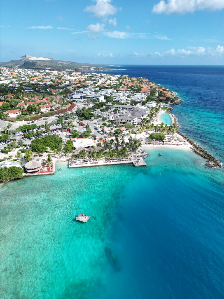 Turquoise waters lapping against golden sand under a clear blue sky at a Curaçao beach