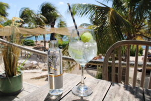 Colorful cocktails at a beach bar in Curaçao promoting the best happy hour spots on the island.