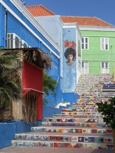 Colorful historic buildings along the waterfront in Willemstad, Curaçao, showcasing Dutch Caribbean architecture and lively city vibes.