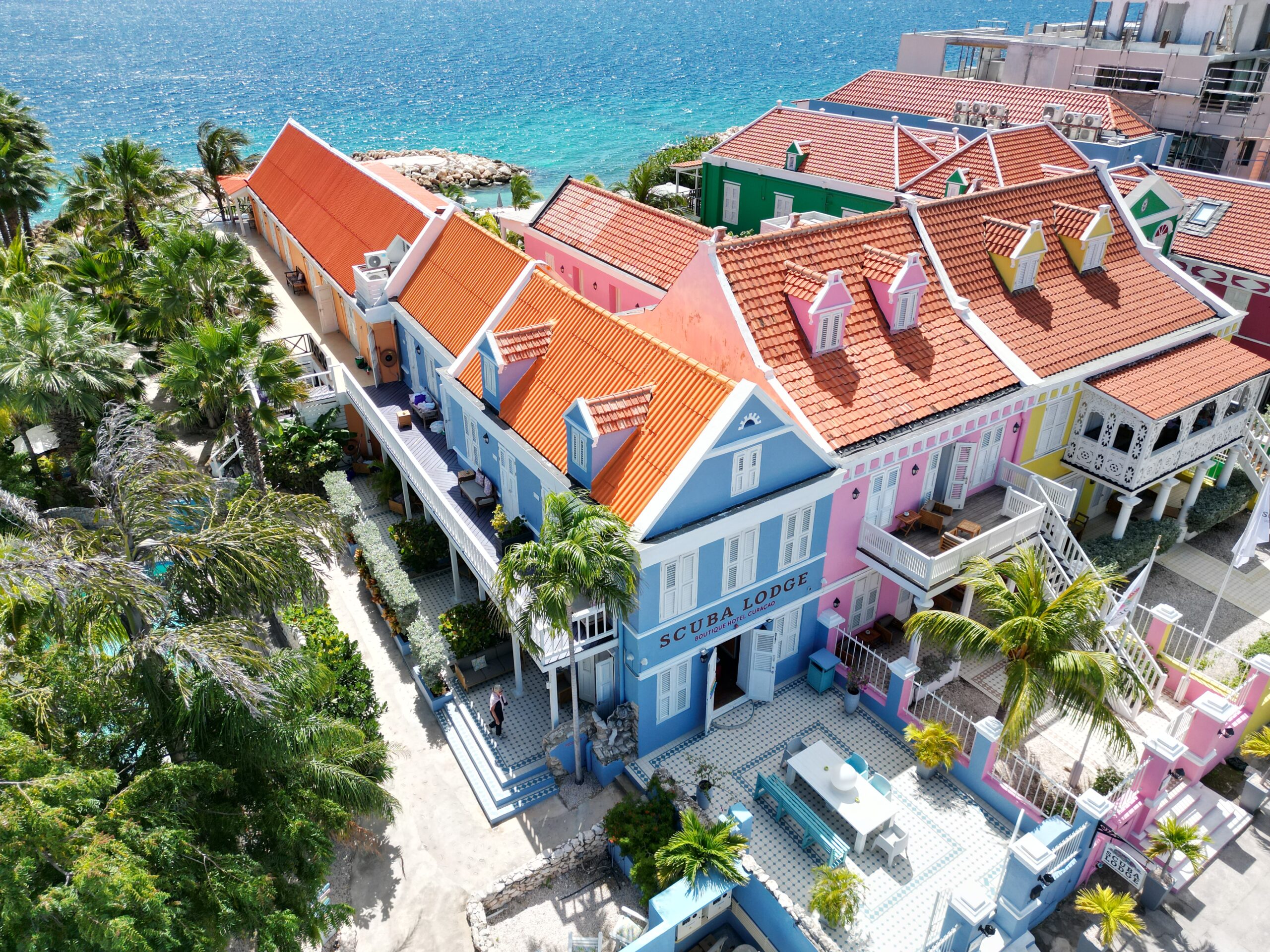 Colorful colonial buildings and boutique hotels in Pietermaai, Willemstad, Curaçao with ocean views and vibrant Caribbean atmosphere.