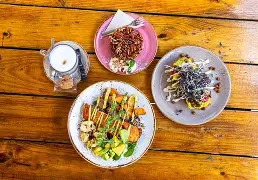 Children playing at a kid-friendly restaurant in Curaçao with outdoor seating, tropical garden, and family-friendly atmosphere.