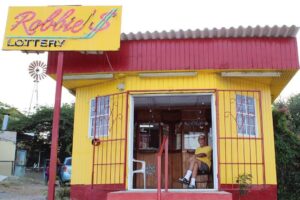 Locals playing domino at a Curaçao snek with laughter and drinks on the table