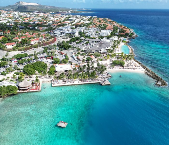 Turquoise waters lapping against golden sand under a clear blue sky at a Curaçao beach